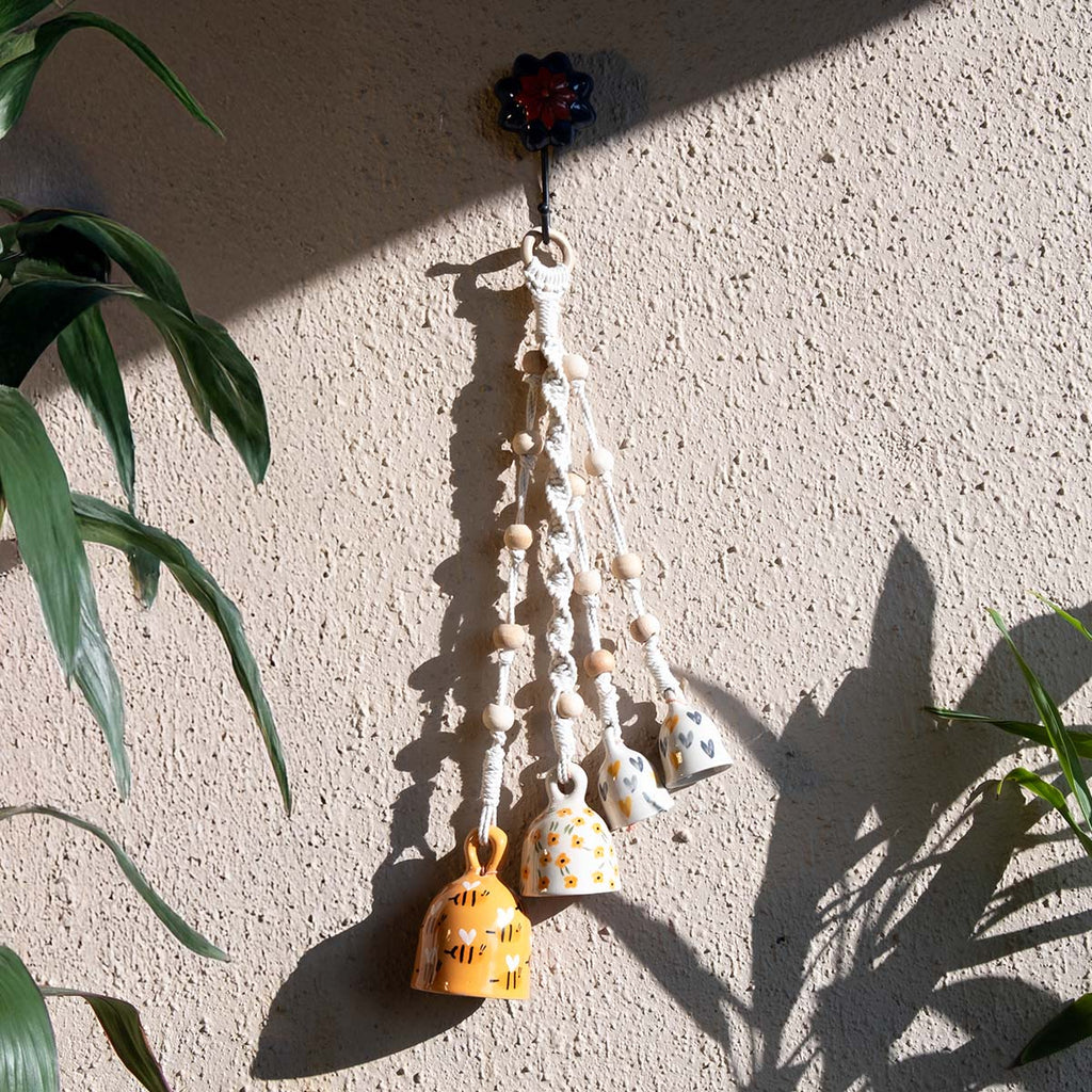 Decorative hanging with beads and small bells on a textured wall