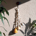Decorative hanging with beads and small bells on a textured wall