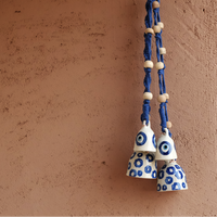 Decorative hanging bells with blue and white design on a brown wall