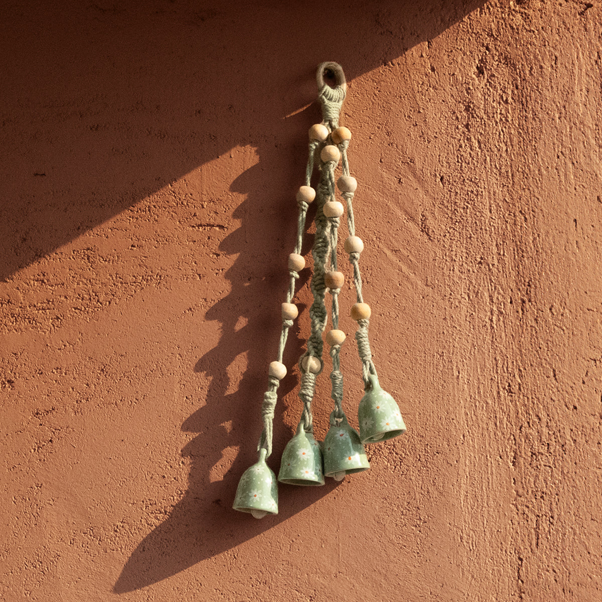 Decorative hanging bells against a textured wall